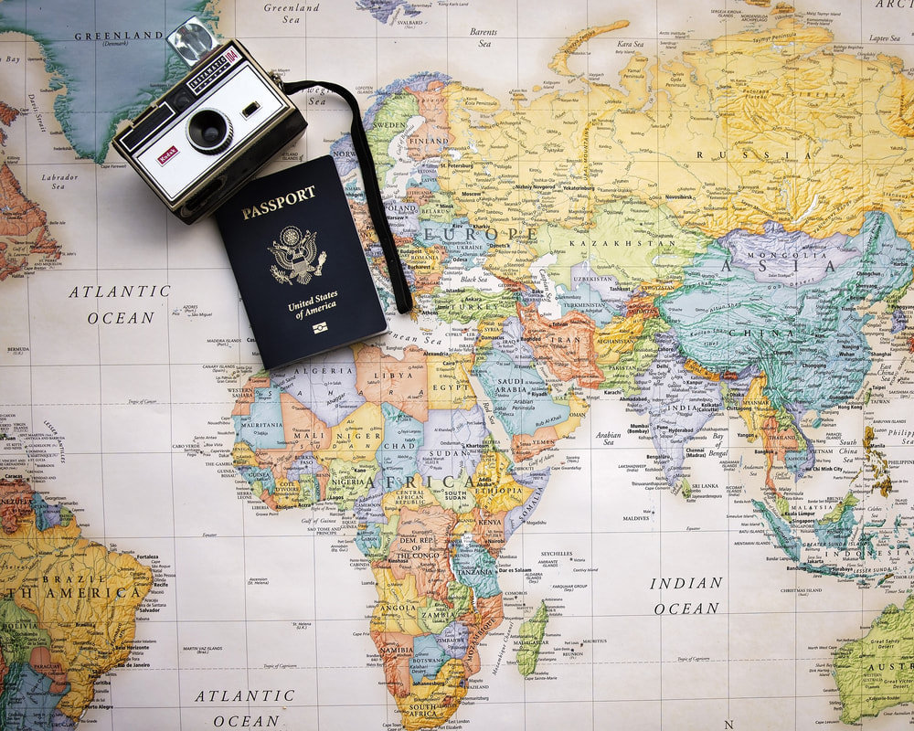 Passaporte e câmera sobre um mapa do mundo