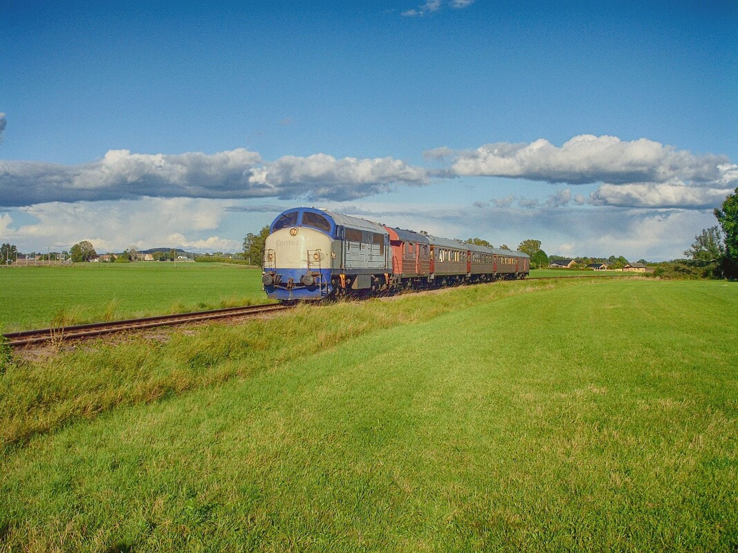 Trem da Suécia cruzando um campo